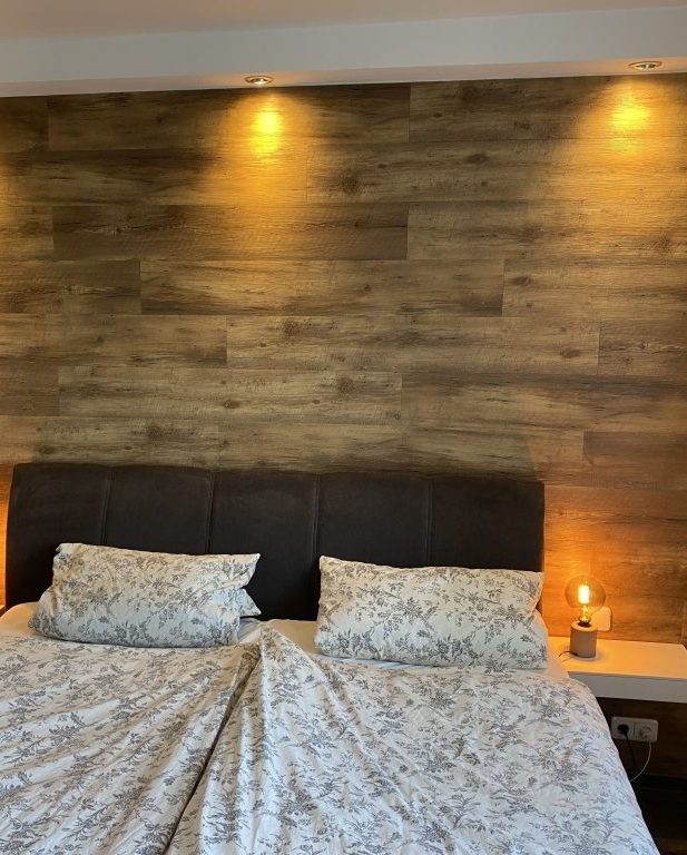 Schlafzimmer mit neu gestalteter Wand in Holzoptik